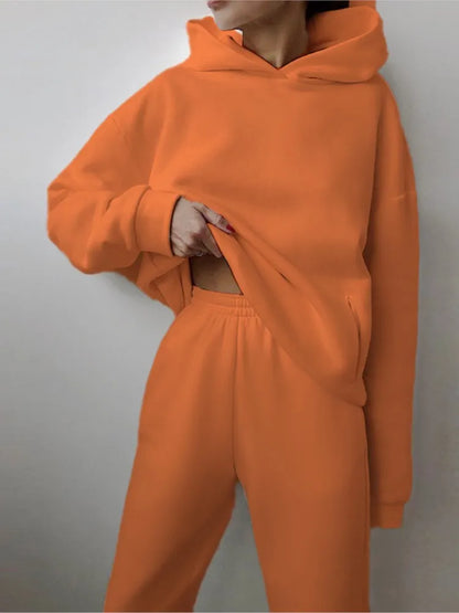 Ensemble décontracté deux pièces pour femme automne-hiver – sweat à capuche épaissi avec poches et pantalon de sport assorti. Tenue mode, ample et confortable.