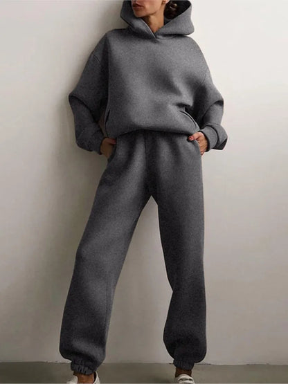 Ensemble décontracté deux pièces pour femme automne-hiver – sweat à capuche épaissi avec poches et pantalon de sport assorti. Tenue mode, ample et confortable.