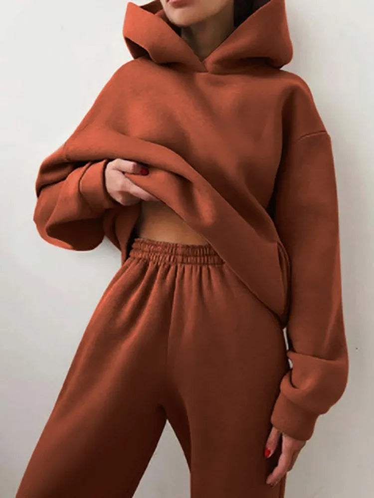 Ensemble décontracté deux pièces pour femme automne-hiver – sweat à capuche épaissi avec poches et pantalon de sport assorti. Tenue mode, ample et confortable.