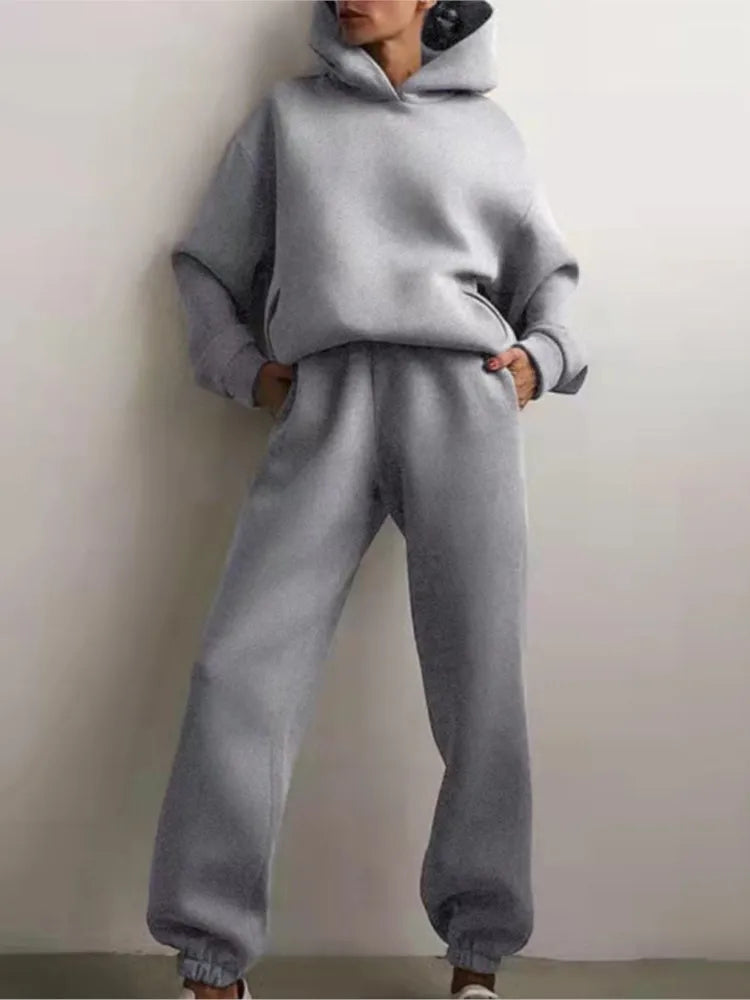 Ensemble décontracté deux pièces pour femme automne-hiver – sweat à capuche épaissi avec poches et pantalon de sport assorti. Tenue mode, ample et confortable.