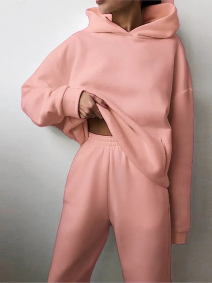 Ensemble décontracté deux pièces pour femme automne-hiver – sweat à capuche épaissi avec poches et pantalon de sport assorti. Tenue mode, ample et confortable.
