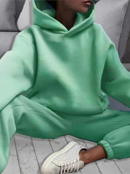 Ensemble décontracté deux pièces pour femme automne-hiver – sweat à capuche épaissi avec poches et pantalon de sport assorti. Tenue mode, ample et confortable.